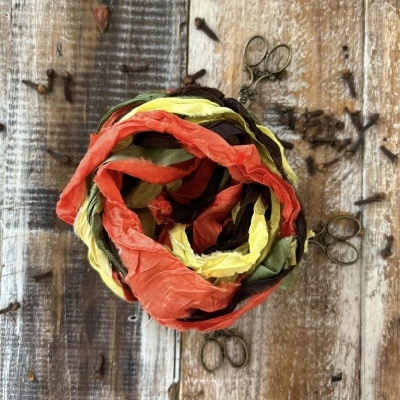 Fita de tecido colorido trançado sobre madeira com tesouras e pregos