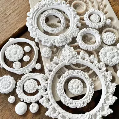 Peças decorativas brancas redondas com padrões florais sobre mesa de madeira.