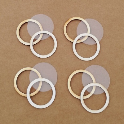 Quatro conjuntos de argolas em madeira clara e círculos translúcidos sobre fundo castanho