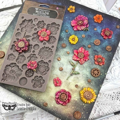 Molde de silicone para flores e elementos circulares decorativos com flores coloridas feitas em cima de uma superfície texturizada.