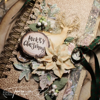 Caderno decorado com temas natalícios incluindo veado de madeira, flores artificiais e etiqueta Merry Christmas