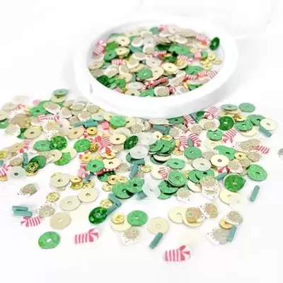 Pequenos discos coloridos verdes e brancos com texturas variadas numa superfície branca com recipiente branco