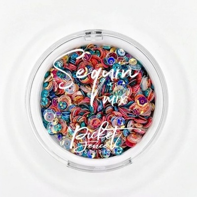 Pote redondo com lantejoulas coloridas e texto branco na tampa.