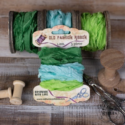 Fitas decorativas em rolos de madeira em verde e azul com etiquetas OLD FASHION RIBBON e HANDMADE WITH LOVE