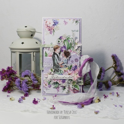 Cartão artesanal com casal jovem e flores roxas sobre renda branca e lanternas