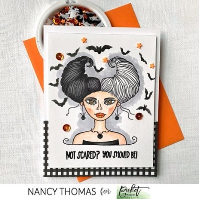 Cartão com ilustração de mulher com cabelo preto e branco, morcegos e confetes à volta