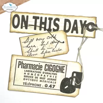 Etiquetas envelhecidas com textos em inglês e francês, cordão e cadeado preto em fundo branco