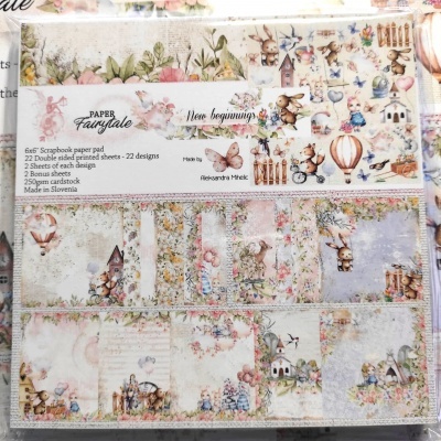 Papel decorativo para scrapbooking com desenhos de coelhos, balões, flores e casas em cores suaves