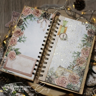 Caderno decorado com flores e glitter aberto em fundo de madeira com luzes