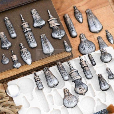 Frascos de perfume vintage prateados gravados sobre caixa de madeira e suporte branco