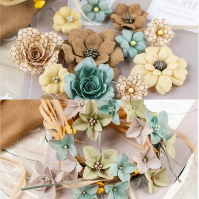 Flores artificiais em tecidos coloridos com texturas variadas e padrões, sobre superfícies claras e tecidos