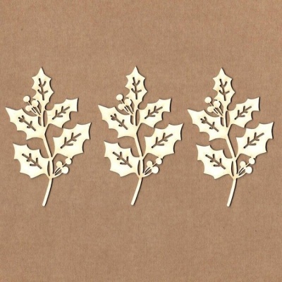 Três recortes de folhas de azevinho em madeira clara sobre superfície castanha