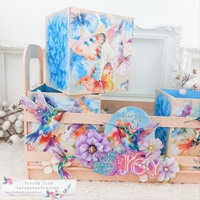 Conjunto decorativo com caixas em madeira e estampas coloridas de borboletas, flores e colibri.