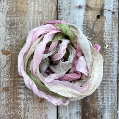 Lenço multicolorido enrolado sobre madeira rústica