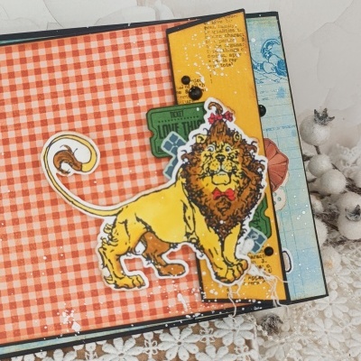 Cartão artesanal com leão ilustrado, fundo xadrez laranja e branco e detalhes em papel colorido