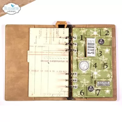 Agenda ou caderno aberto com capa em couro castanho e folhas decorativas com temática natalícia