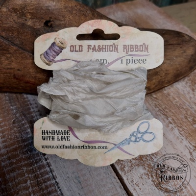 Fio branco texturizado enrolado num cartão com desenhos e texto OLD FASHION RIBBON