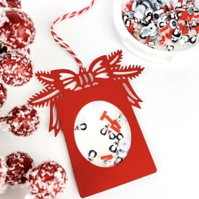 Etiqueta vermelha decorativa com enfeites e raminho de bagas vermelhas nevadas