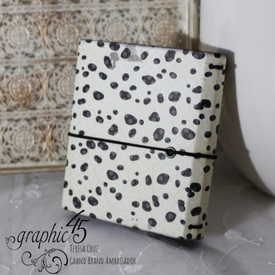 caderno branco com manchas pretas e elástico preto