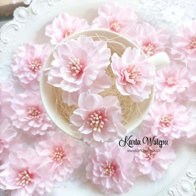 Flores decorativas cor-de-rosa em chávena com prato branco