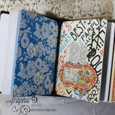 Caderno aberto com capa interior azul floral e página com texto colorido e etiqueta decorativa