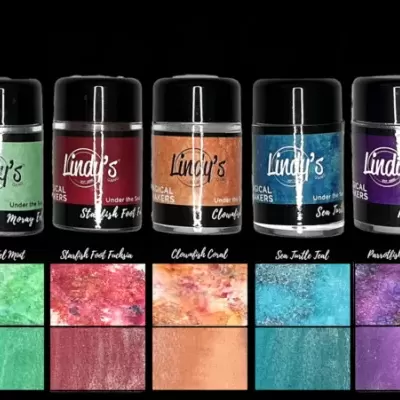 Cinco frascos de pigmentos spray Lindi's em várias cores com amostras correspondentes.