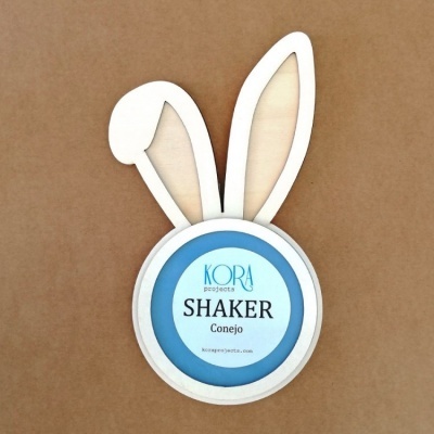 Shaker de madeira clara em forma de coelho com texto KORA projetos SHAKER Conejo