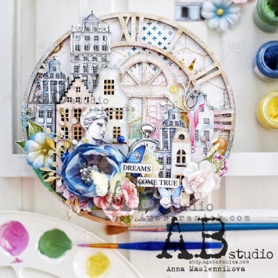 Relógio decorativo redondo com casas desenhadas, flores coloridas, texto 'DREAMS COME TRUE' e pincéis ao lado