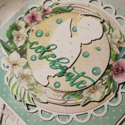 Cartão artesanal com anjo branco, palavra celebrate verde, flores e padrão rendado
