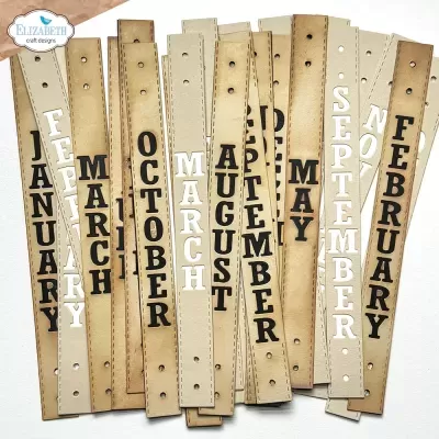 Abas de papel com meses do ano em inglês em letras brancas e pretas, fundo envelhecido e logo ELIZABETH craft designs