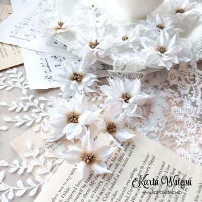 Flores artificiais brancas sobre papel e tecido rendado