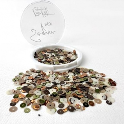 Recipiente aberto com lantejoulas coloridas espalhadas sobre uma superfície branca