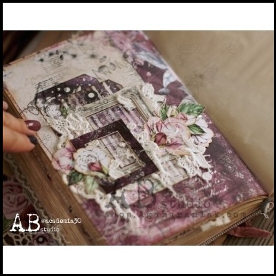 Página de livro decorada com recortes, renda e flores em tons rosa e branco