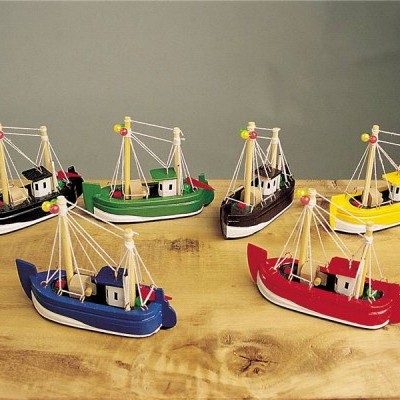 Seis miniaturas de barcos de pesca coloridos em madeira sobre mesa de madeira