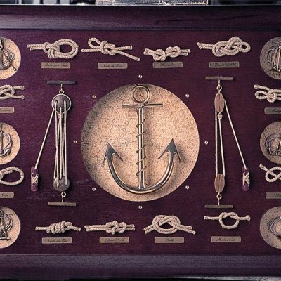 Quadro decorativo com âncora central e vários nós náuticos em corda clara