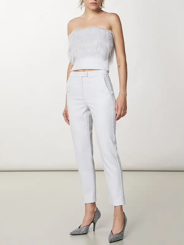 Patrizia Pepe Hvide Habitbukser Conjunto branco feminino com top de franjas e calças justas, usando sapatos de salto xadrez.