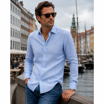 Homem com camisa azul clara e óculos de sol junto a canal com barcos e edifícios coloridos