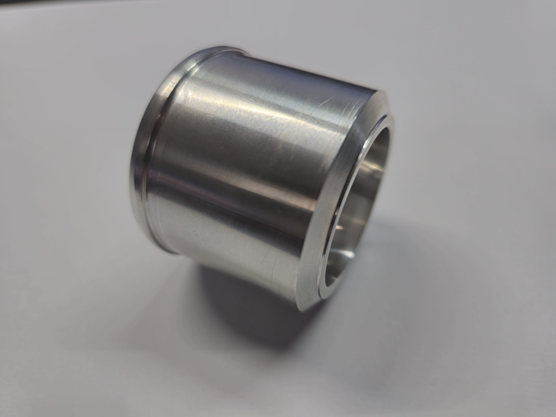 Peça cilíndrica metálica polida sobre fundo branco