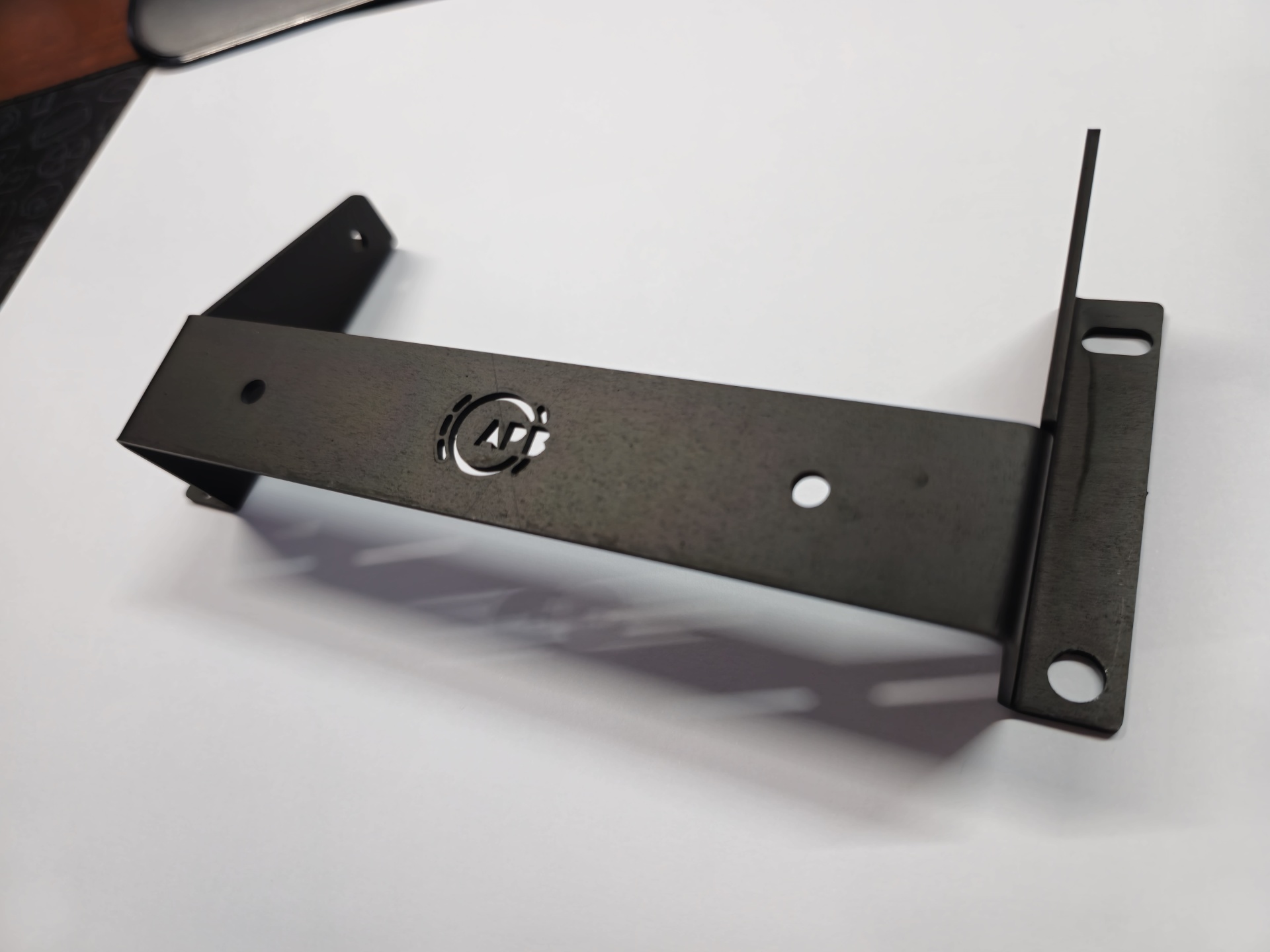 Suporte metálico preto angular com furos de fixação