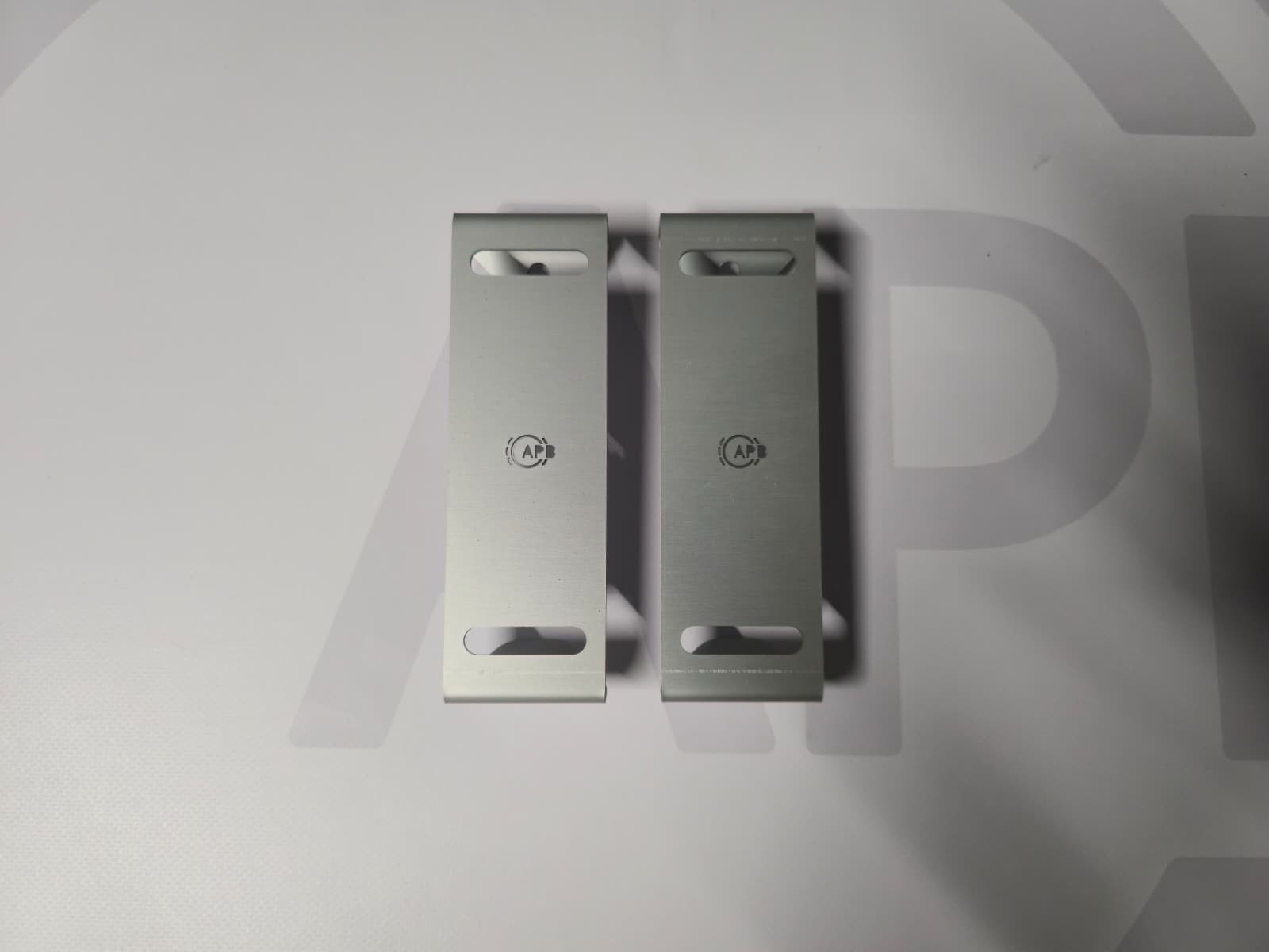 Two metal brackets with '1 WP' text on a light surface.