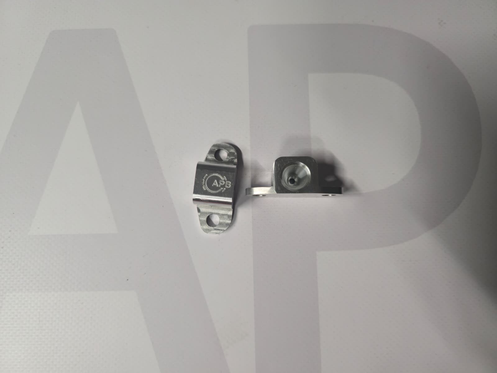 Two small silver metal brackets with APB engraving on a white background