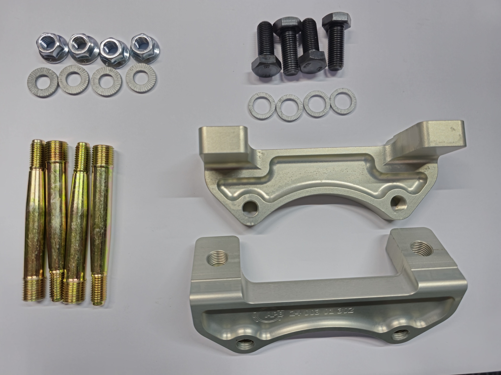 Conjunto de parafusos, porcas, arruelas e peças metálicas prateadas sobre fundo branco