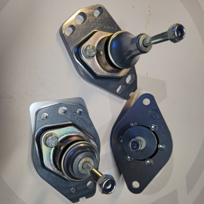 Three metal automotive suspension ball joints with nuts and mounting plates
