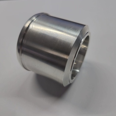 Peça cilíndrica metálica polida sobre fundo branco