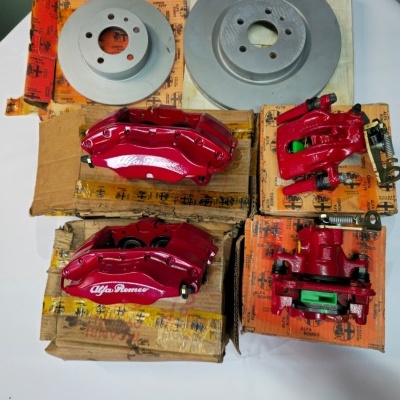 Red Alfa Romeo brake calipers and silver brake discs on branded boxes