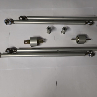 Componentes metálicos incluindo braços telescópicos, cilindros e adaptadores sobre superfície branca