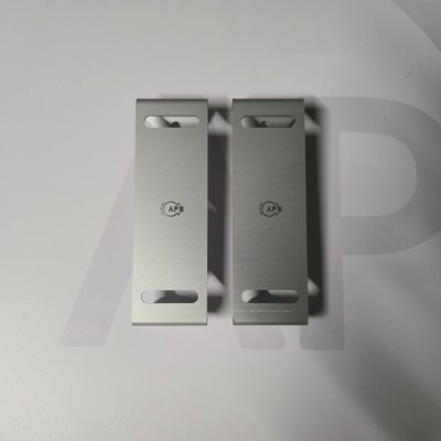 Two metal brackets with '1 WP' text on a light surface.