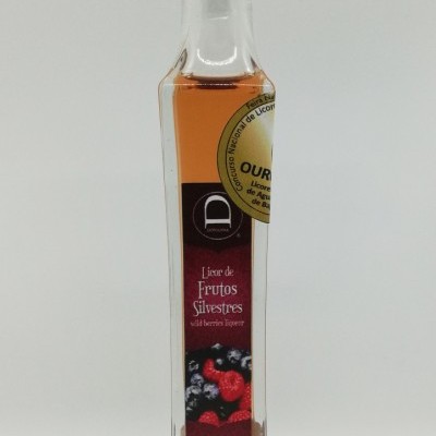 Garrafa de licor de frutos silvestres com rótulo vermelho e selo dourado