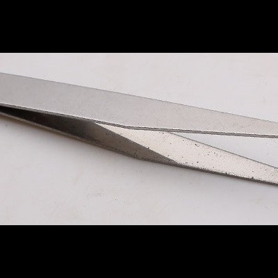 Pinça metálica prateada com pontas curvadas