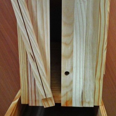 Caixa de madeira clara com tampa deslizante aberta e peça destacável